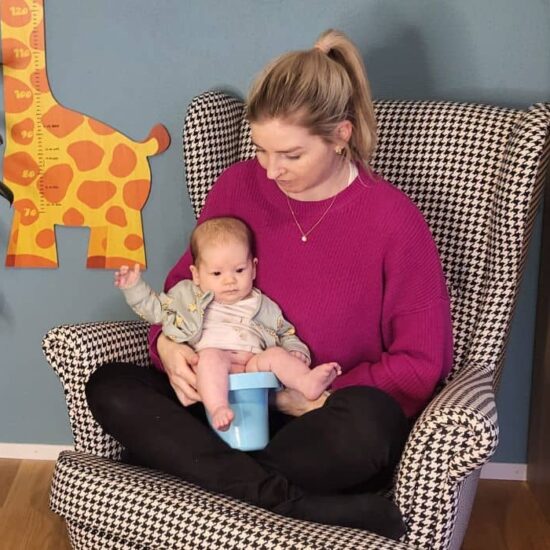 Kind wird über Töpfchen gehalten